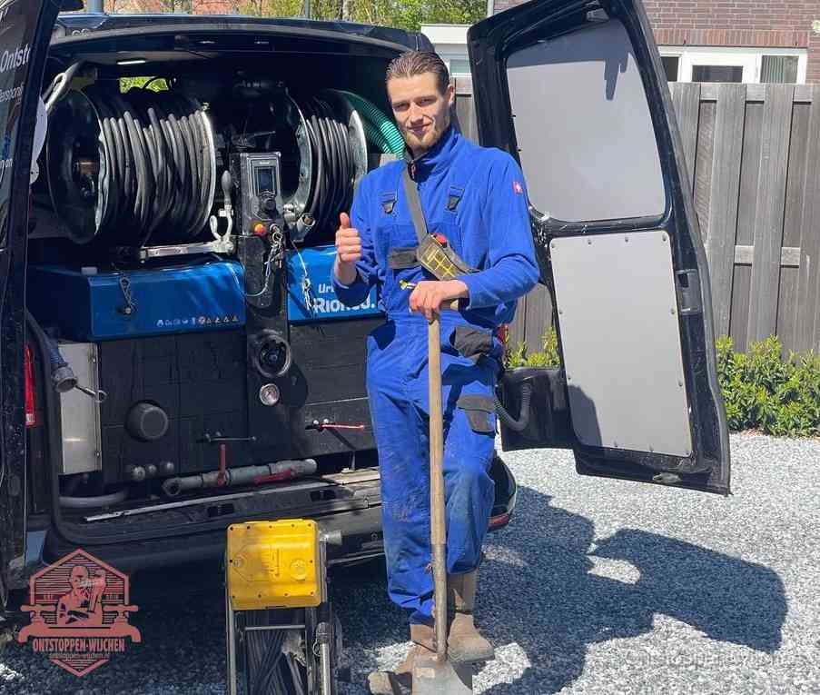 Een monteur bij de werkbus met grote hogedruk-slanghaspels, apparatuur voor hardnekkige afvoerverstoppingen in Wijchen