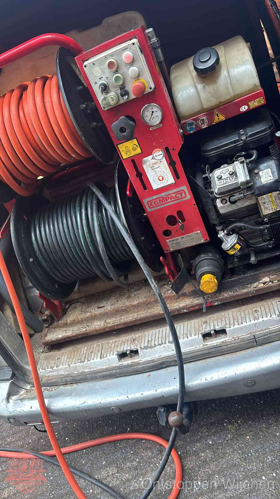 Een rood hogedruk-rioolreinigingstoestel met slangen in de laadbak van de bedrijfsbus, apparatuur voor een hardnekkige wc-verstopping in Wijchen