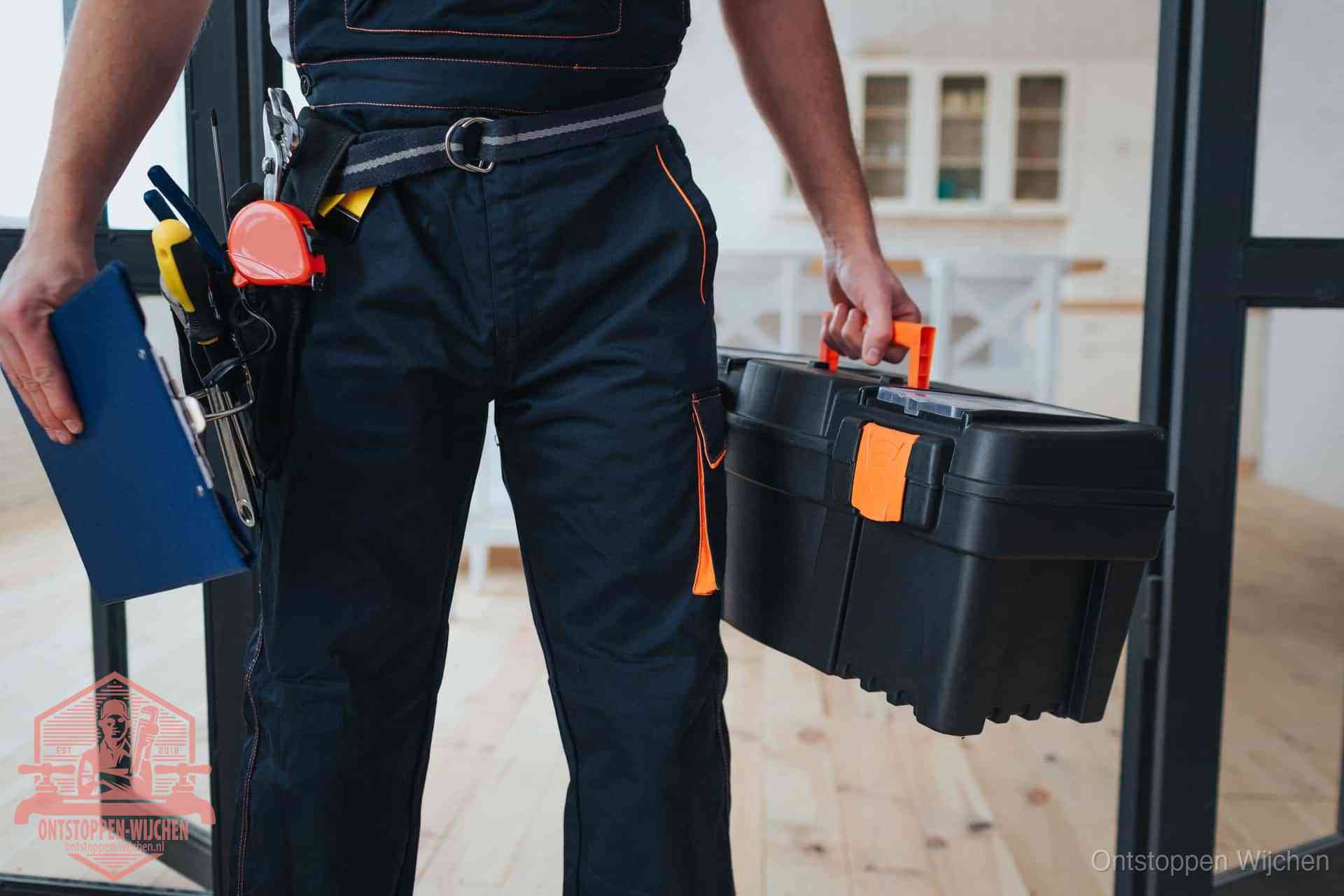 Een monteur met gereedschapsriem en klembord in een keuken, klaar om een transparante prijs voor het gootsteen ontstoppen in Wijchen te geven