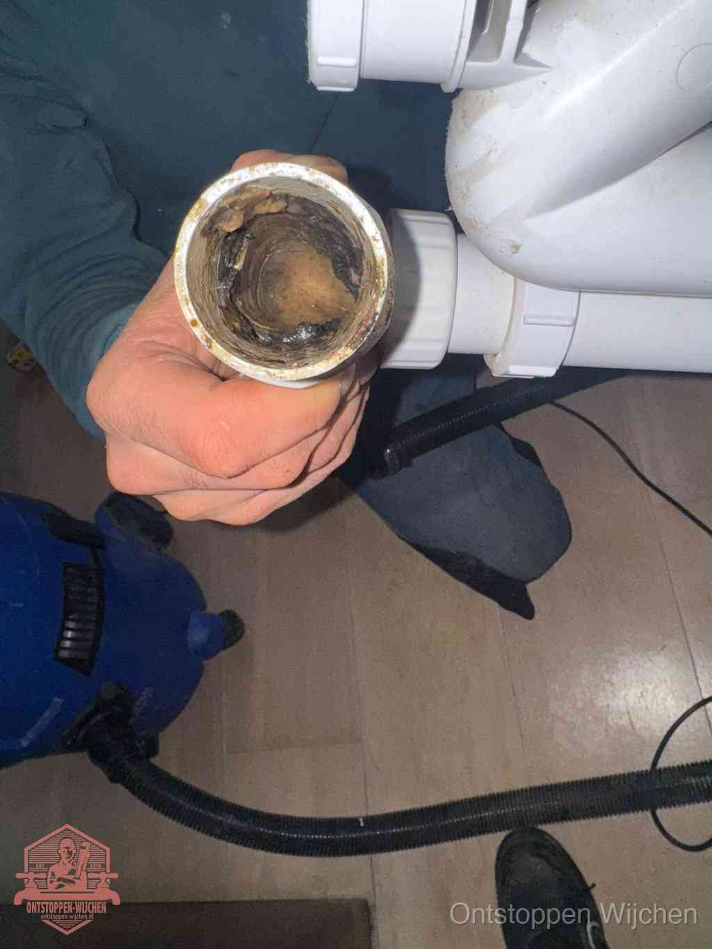 Een losgekoppelde afvoerbuis die van binnen volledig is dichtgeslibd met vet en aanslag, de meest voorkomende oorzaak van een verstopte gootsteen in Wijchen