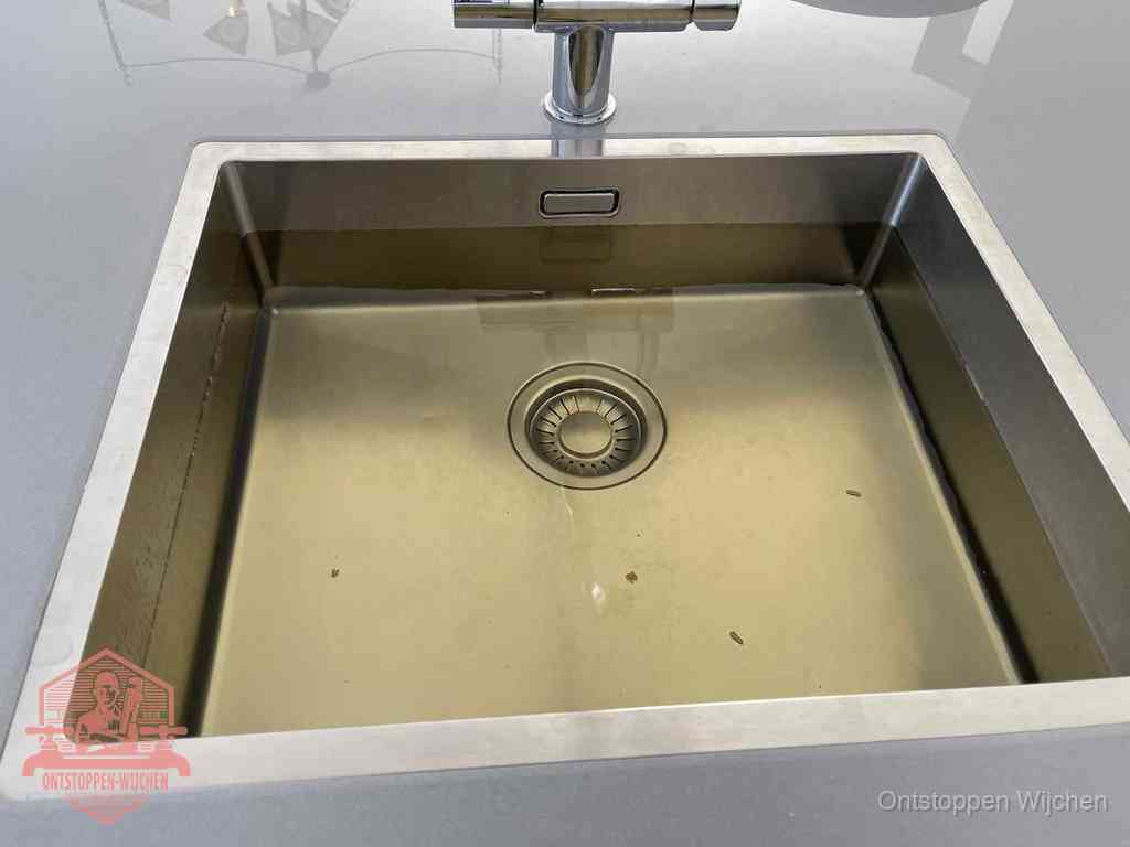 Stilstaand water in een rvs spoelbak dat niet wegloopt, een duidelijk signaal van een gootsteenverstopping in Wijchen