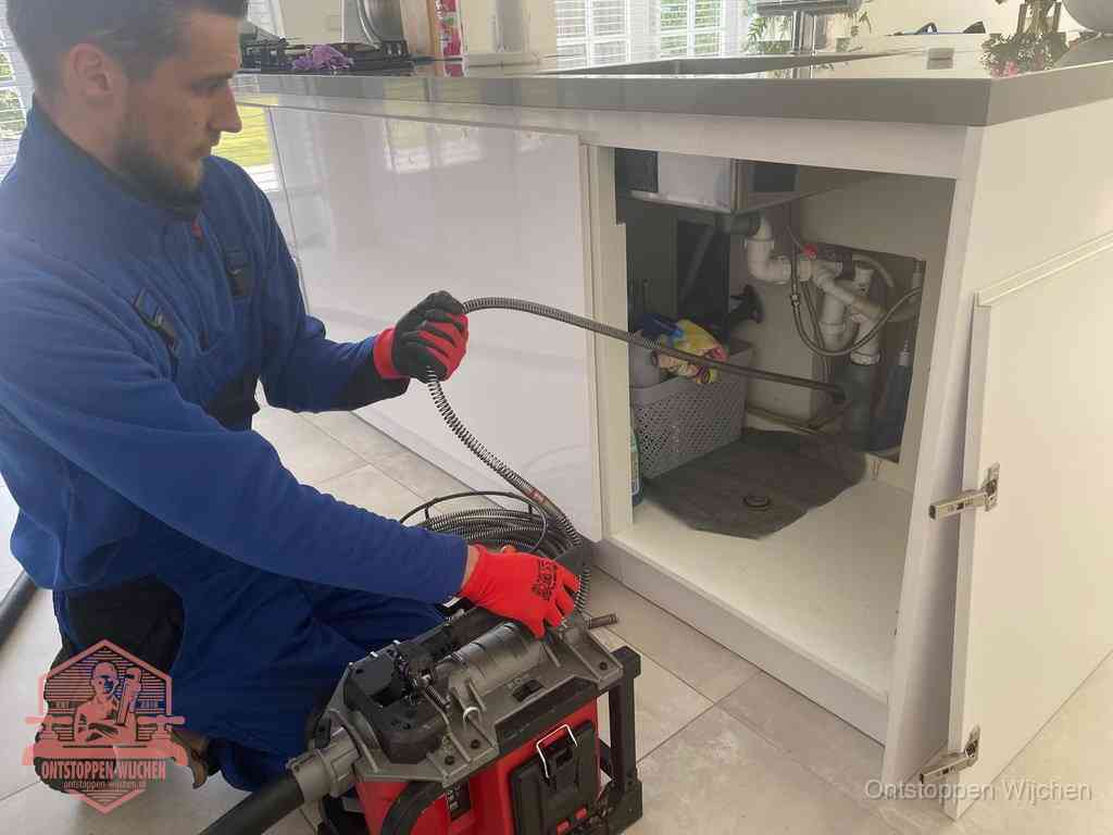 Een monteur reinigt de keukenafvoer grondig met een veermachine om terugkerende gootsteenverstoppingen te voorkomen in Wijchen