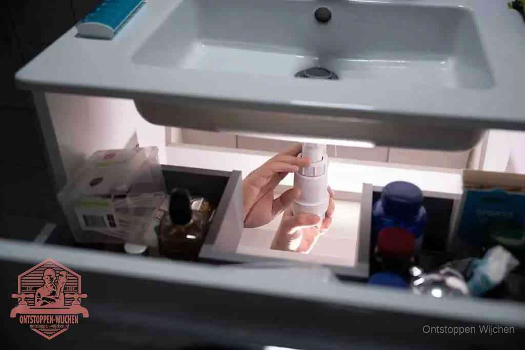 Een pompfles met zeep boven een wastafel in de toiletruimte, de warm water en afwasmiddel-methode om de wc te ontstoppen in Wijchen