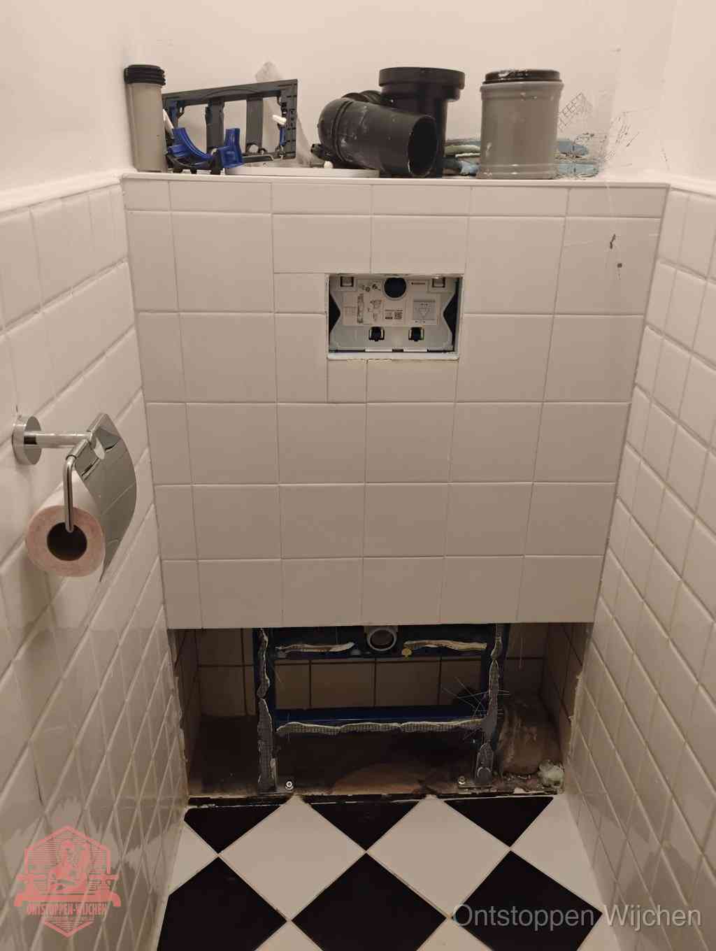 Een toiletruimte waar het hangtoilet en de inbouwreservoir-onderdelen zijn vrijgelegd voor onderhoud, periodiek nazicht voorkomt een wc-verstopping in Wijchen